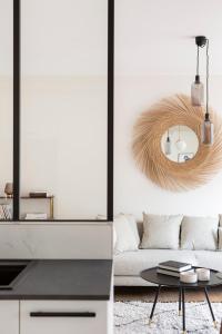 a living room with a couch and a mirror at L'Eden - Appartement familial au pied du Thabor in Rennes