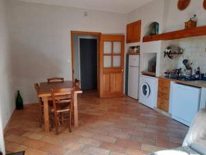 a kitchen with a wooden table and a kitchen with a stove at Les Néfliers in Maillane