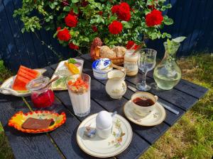 a picnic table with food and cups of coffee and flowers at KirkeLy Bed and Breakfast in Vester Ulslev