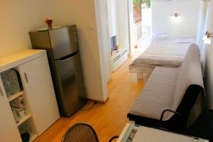 uma cozinha com um frigorífico e um sofá num quarto em Apartment Studio Olga em Novi Vinodolski