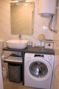 uma casa de banho com uma máquina de lavar roupa e um lavatório em Apartment Studio Olga em Novi Vinodolski