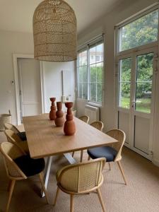 comedor con mesa de madera y sillas en Villa Marguerite, en Lège-Cap-Ferret