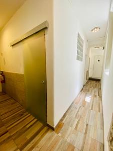 a hallway with a green door and a wooden floor at My Friends in Florence