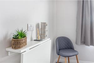 una silla sentada junto a un escritorio blanco con una planta en Guest Homes - The Bull Inn, 3 Double Rooms en Worcester