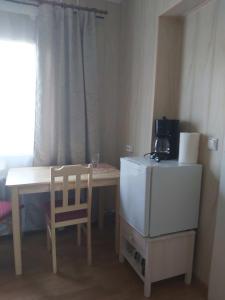 a kitchen with a table and a refrigerator and a chair at Kanepi accommodation One room in Viljandi