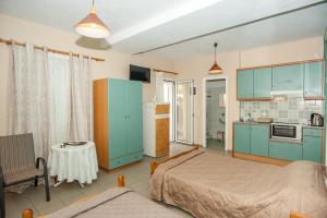 a bedroom with a bed and a kitchen with blue cabinets at Folies in Lourdata