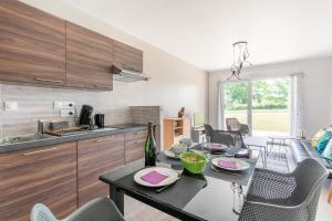- une cuisine et une salle à manger avec une table et des chaises dans l'établissement Eolia, à Dinard
