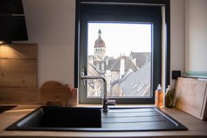 eine Küchenspüle mit Blick auf ein Fenster in der Unterkunft Les Terrasses de Notre Dame in Beaune