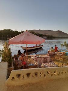 a group of people sitting at a table under an umbrella at Baba Dool in Aswan