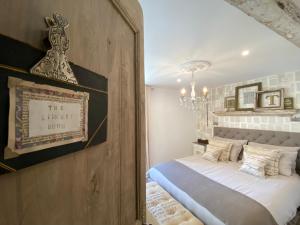 a bedroom with a bed and a chandelier at Maison Mûrier in Fayssac