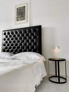 a bedroom with a black headboard and a table at B&B Blessed apartment in Perugia