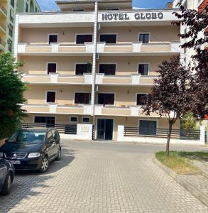 two cars parked in front of a hotel cloco at Hotel Globo in Durrës