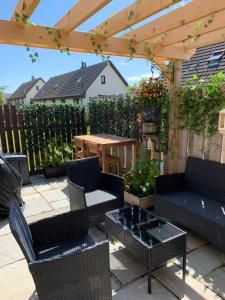 a patio with chairs and tables and a wooden pergola at Aaron's Bothy in Portree