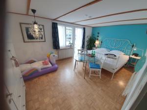 ein Wohnzimmer mit einem Tisch und ein Kinderschlafzimmer in der Unterkunft BnB Haus Weibel in Landquart