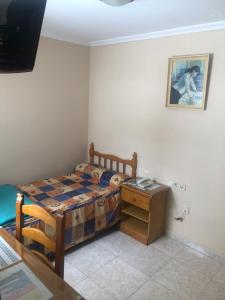 a small bedroom with a bed and a table at HOSTAL ALGECIRAs in Algeciras