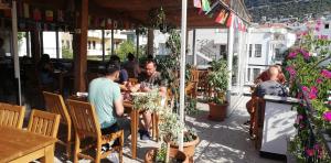 un grupo de personas sentadas en una mesa en un restaurante en meltem pansiyon en Kas