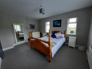 een slaapkamer met een bed, een dressoir en een spiegel bij Island View Bed and Breakfast in Doolin