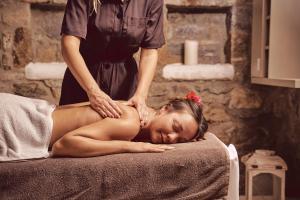 a woman getting a massage from a therapist at Villa Petrolefko By Ethos Hospitality in Ornos