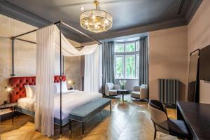Lion's Castle Hotel في إلفيف: غرفة نوم بسرير مظلة وطاولة وكراسي