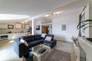 ein Wohnzimmer mit einem blauen Sofa und einer Küche in der Unterkunft VILLA Mira in Trogir