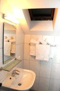 a bathroom with a sink and a mirror and towels at Appartement - Pension Adlerhorst in Velden am Wörthersee