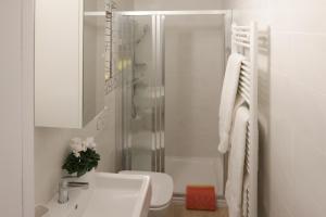 a white bathroom with a sink and a shower at San Giuan, ad un passo dal centro in Chiavenna