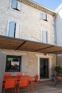 un patio avec une table et des chaises et un bâtiment dans l'établissement Maison de ville provençale - tout confort, à Saint-Rémy-de-Provence