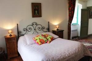 a bedroom with a white bed with two pillows on it at Domaine De Syam - Gîtes, Chambres d'hôtes & Cabanes in Syam