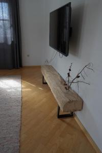 a living room with a wooden bench and a flat screen tv at Ferienwohnung Miedl in Hauzenberg