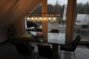 uma sala de jantar com uma mesa de vidro e lustre em Zweit-Traumwohnung em Marburg an der Lahn