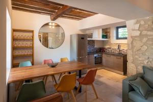 une cuisine et une salle à manger avec une table et des chaises en bois dans l'établissement Maison de ville provençale - tout confort, à Saint-Rémy-de-Provence