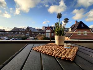 une table en bois avec une plante au-dessus d'un balcon dans l'établissement Strand Koje, à Westerland