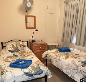 a bedroom with two beds and a dresser and a mirror at Homely Cottage in Hawker