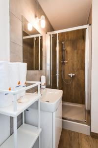 een witte badkamer met een douche en een wastafel bij Mobile Home Vodice 27 in Vodice