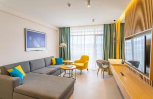 a living room with a couch and a tv at Hotel Sevtopolis Medical & SPA in Pavel Banya
