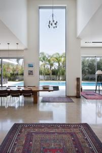 ein Esszimmer mit einem Tisch und einem großen Fenster in der Unterkunft Villa Alice Caesarea in Caesarea