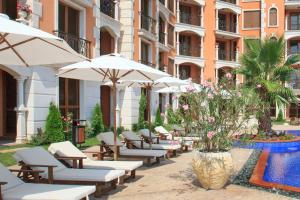 a row of chairs and umbrellas next to a building at Cascadas Ravda in Ravda