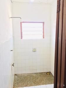 a bathroom with a white tiled shower with a window at Feel At Home & be close to the Labadi Beach (5min) in Accra