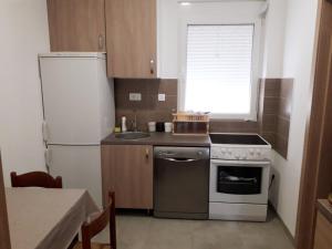 a small kitchen with a stove and a refrigerator at Adriatic Sunset House in Petrovac na Moru