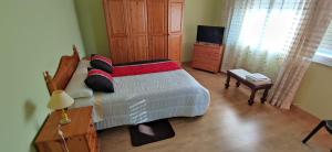 a bedroom with a bed and a dresser and a television at HOSTAL BODEGÓN A COSECHA in San Ciprián