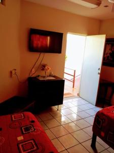 Habitación con dormitorio con cama y puerta en Apartamentos osuna, en Mazatlán