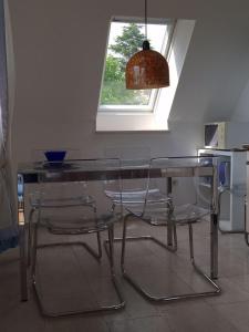 einen Glastisch und Stühle in einer Küche mit Fenster in der Unterkunft Ferienwohnung Gottorf in Ulsnis
