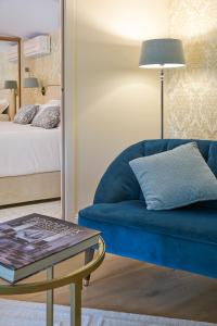 a living room with a blue couch and a table at Chateau Pont Saint-Martin in Léognan