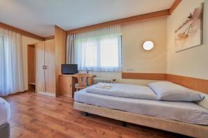 a hotel room with a bed and a television at Pension Sonnwend in Fieberbrunn