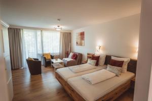 a living room with a large couch and a living room with a couch at Hotel Berghof Graml in Hallwang