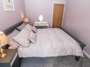 a bedroom with a bed with a white bedspread at Medical Hall in Cemaes Bay