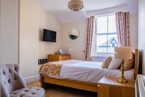 a bedroom with a bed and a window at Arvon House in Llandudno