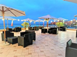 a patio with tables and chairs and umbrellas at Sea Garden Rooms in Termoli