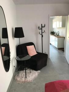 sala de estar con sofá negro y mesa en Apartamenty Gietrzwałd, en Gietrzwałd