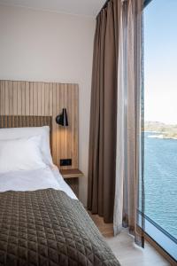 a bedroom with a bed and a large window at Quality Hotel Ramsalt in Bodø